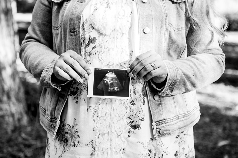 Maman enceinte montrant la photo de son échographie